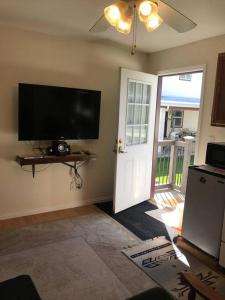 a living room with a flat screen tv and a door at Cozy Cottage House B with Double Carport in Twin Falls