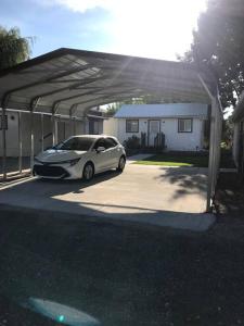 a car parked under a garage in a driveway at Cozy Cottage House B with Double Carport in Twin Falls