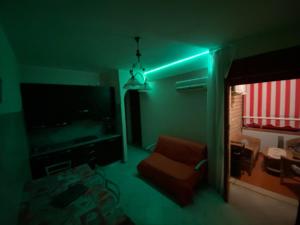 een woonkamer met een groen licht en een televisie bij Apartement Mimosa in Scalea