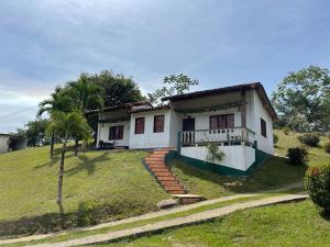uma casa branca numa colina com uma palmeira em Hotel Candilejas em Puerto Berrío