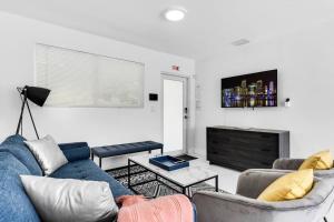 een woonkamer met een blauwe bank en een tv bij Modern Getaway 4BRs House with Pool and Game Room in Hollywood