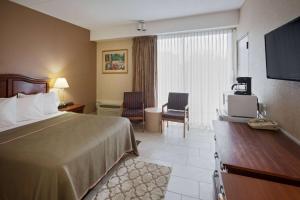 una camera d'albergo con letto e TV di Howard Johnson by Wyndham Toms River a Toms River