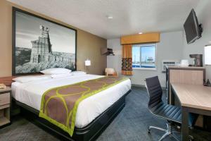 a hotel room with a large bed and a desk at Super 8 by Wyndham Amarillo in Amarillo