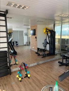 a room with a gym with mirrors and tread machines at Flat em Taguatinga in Taguatinga
