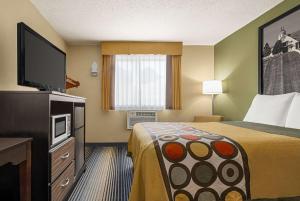 A bed or beds in a room at Super 8 by Wyndham Maysville KY