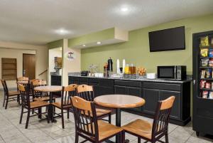 un restaurante con mesas y sillas y un bar en Super 8 by Wyndham Maysville KY en Maysville