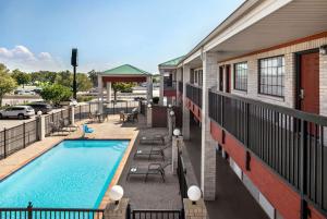 サンアントニオにあるDays Inn by Wyndham San Antonio Near Fiesta Parkのプールの景色を望むバルコニーが備わります。