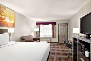 a hotel room with a bed and a tv at Days Inn by Wyndham San Antonio Near Fiesta Park in San Antonio