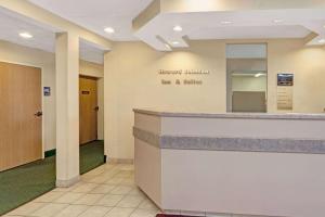 a hotel lobby with a reception desk and a mirror at Red Lion Inn & Suites Elk Grove Village in Elk Grove Village