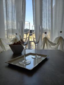 Quartopiano Guesthouse في روما: كأسين من النبيذ يجلسون على صحن على طاولة