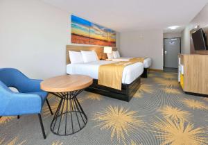 a hotel room with a bed and a table and a chair at Days Inn by Wyndham Tunica Resorts in Tunica Resorts