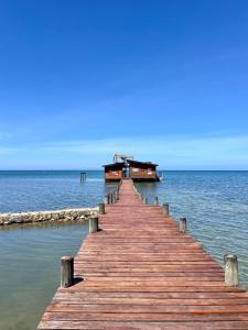 a wooden pier in the water with a boat at The Resort at Marble Hill in Diamond Rock