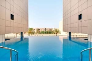 uma grande piscina no meio de dois edifícios em Ramada Hotel and Suites Amwaj Islands em Manama