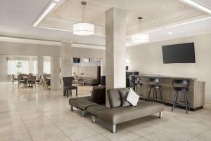 a lobby with a couch and chairs and a bar at La Quinta by Wyndham Brownsville North in Brownsville