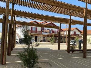 budynek z drewnianymi pergolami na parkingu w obiekcie La résidence la Pomme de Pin - Vieux-Boucau-les-Bains - 3 pièces, 6 personnes w mieście Vieux-Boucau-les-Bains
