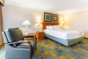 um quarto de hotel com uma cama e uma cadeira em La Quinta by Wyndham Redding em Redding