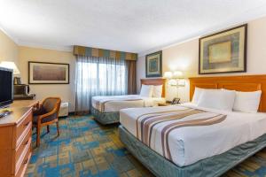 a hotel room with two beds and a television at La Quinta by Wyndham Redding in Redding