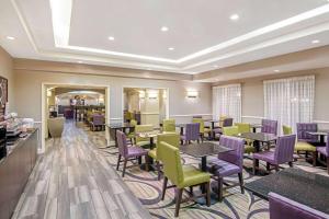 a restaurant with purple and green chairs and tables at La Quinta by Wyndham San Antonio Airport in San Antonio