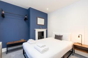 una camera da letto con pareti blu e un letto bianco di The Bakery A Renovated Gem in Central Brighton a Brighton & Hove