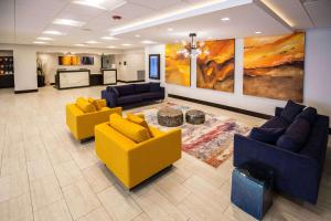 a lobby with yellow and blue couches in a building at Wyndham Chicago O'Hare in Rosemont