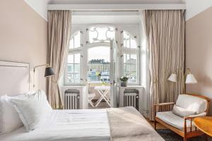 ein Schlafzimmer mit einem Bett, einem Stuhl und einem Fenster in der Unterkunft Hotel Esplanade, BW Signature Collection in Stockholm