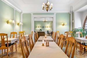a dining room with tables and chairs and a chandelier at Hotel Esplanade, BW Signature Collection in Stockholm