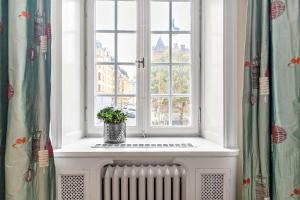 a window with a potted plant sitting on a radiator at Hotel Esplanade; Sure Hotel Collection by Best Western in Stockholm