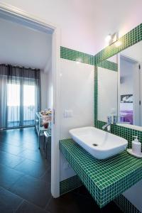 baño verde y blanco con lavabo y espejo en Bed and Breakfast Palermo Centro, en Palermo