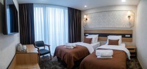 una camera d'albergo con due letti e una sedia di Hotel Solum Roof Top a Tbilisi City