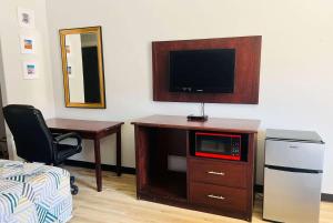 a room with a tv and a desk with a microwave at Baymont by Wyndham Ridgecrest in Ridgecrest