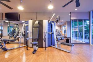 a gym with several tread machines in a room at Zenmaya Oceanfront Phuket, Trademark Collection by Wyndham in Patong Beach
