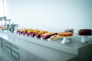 a buffet with many different types of cakes and pastries at Hotel H2 Congonhas in Congonhas