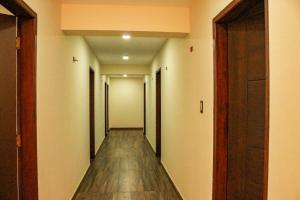 Un pasillo vacío con un largo piso de madera y puertas. en Hotel Sky - Tarija, en Tarija