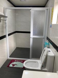 a small bathroom with a shower with a toilet at Tianen Farm in Hualing