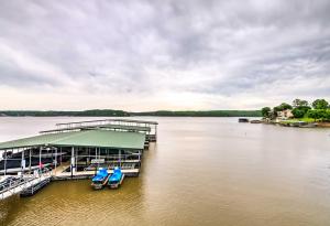 een steiger op een meer met twee blauwe stoelen bij Lakefront Osage Beach Condo Dock Your Boat Here! in Osage Beach