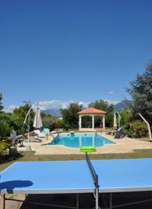 einen großen Pool mit einem Tisch und einem Pavillon in der Unterkunft Aile de villa climatisée avec piscine in Porticcio