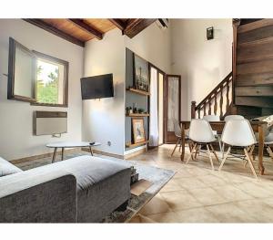 ein Wohnzimmer mit einem Sofa, einem Tisch und Stühlen in der Unterkunft Aile de villa climatisée avec piscine in Porticcio