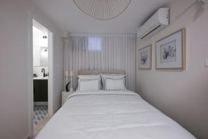 a white bedroom with a large bed with white pillows at סוויטת בוטיק נטע in Neta‘im