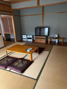a living room with a table and a tv at 山水民宿 in Takayama