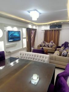 a living room with a table and a tv at للعائلات فقط the fardous apartment sea view in Alexandria +12 photos
