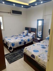 a bedroom with two beds and a mirror at للعائلات فقط the fardous apartment sea view in Alexandria