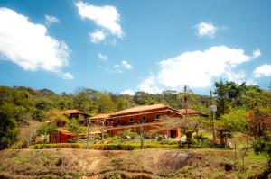 a building on a hill with trees in the background at ECO RESORT FASCINAÇÃO in Miguel Pereira
