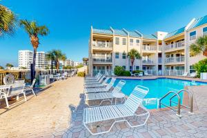 a row of lounge chairs next to a swimming pool at Poolside Villas #206 in Destin