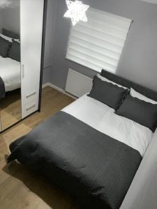 a bedroom with a black and white bed and a mirror at Ideal Abode Greenfields in Chester