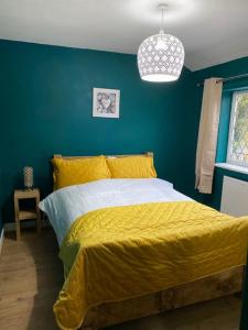 a bedroom with a yellow bed with a blue wall at Ideal Abode Greenfields in Chester