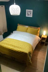 1 dormitorio con 1 cama con edredón amarillo en Ideal Abode Greenfields, en Chester