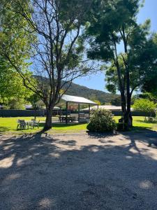 a picnic area with trees and a pavilion in a park at Willow Dene Holiday Apartments in Bright