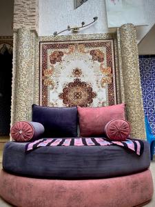 Cama en habitación con almohadas y pared en Riad Essalam en Rabat