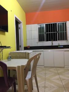 a kitchen with a table and chairs in a room at Lençóis Hospedagens in Barreirinhas