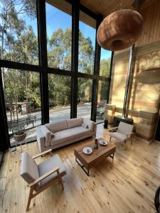 a living room with a couch and chairs and a table at Tripanko Lodge & Bungalows in Pichilemu